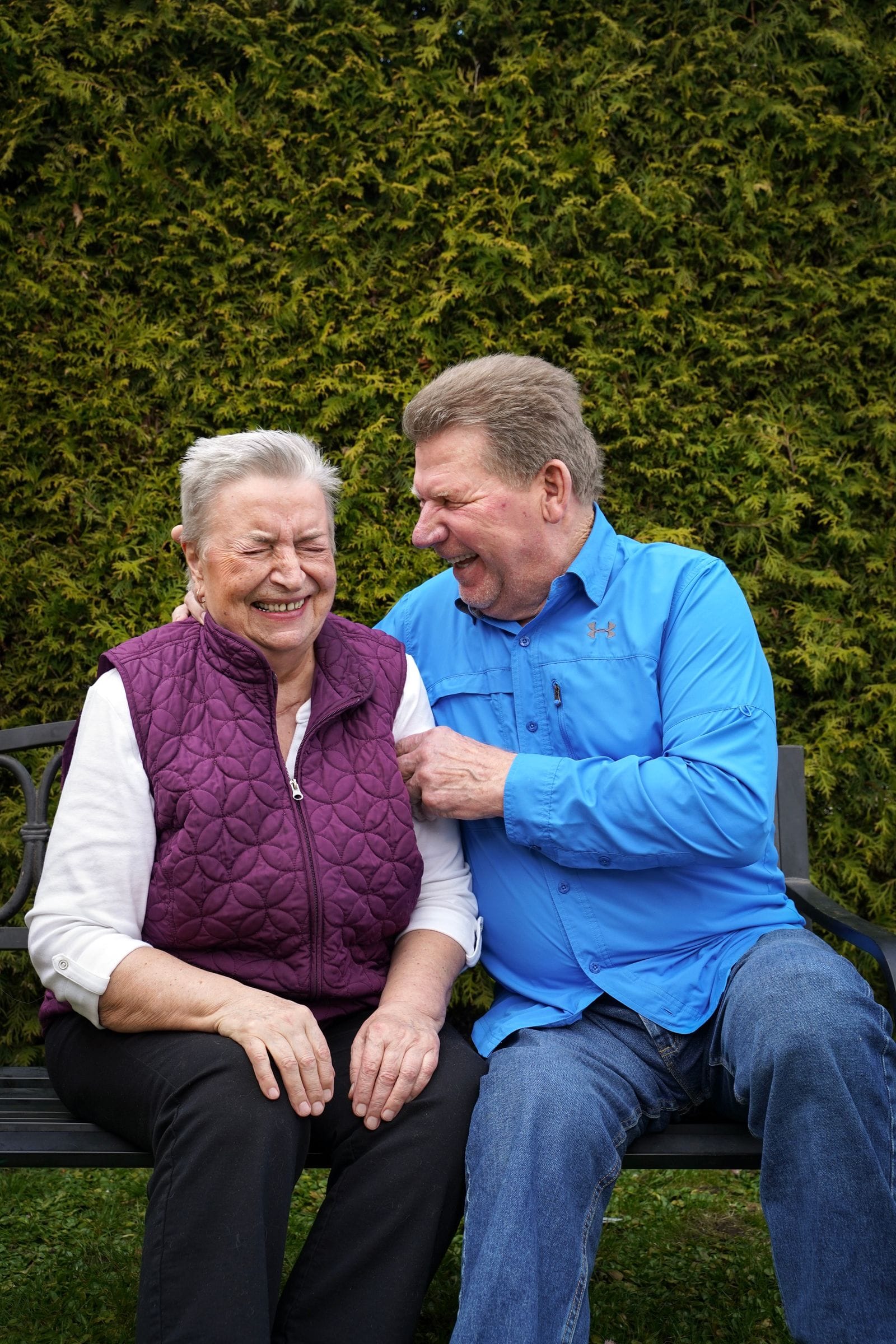 Pareja de adultos mayores riendo juntos al aire libre