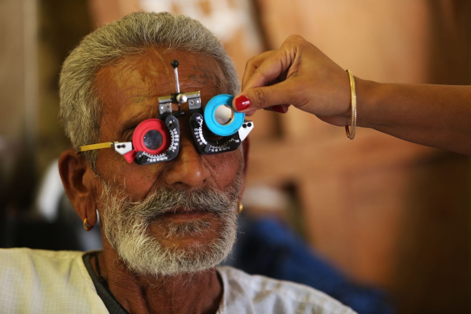 Hombre mayor durante un examen de visión con lentes de prueba, revisando su salud visual